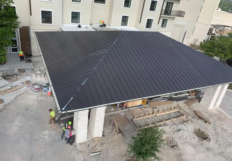 Metal roofing installation team working on a commercial building in Hamilton